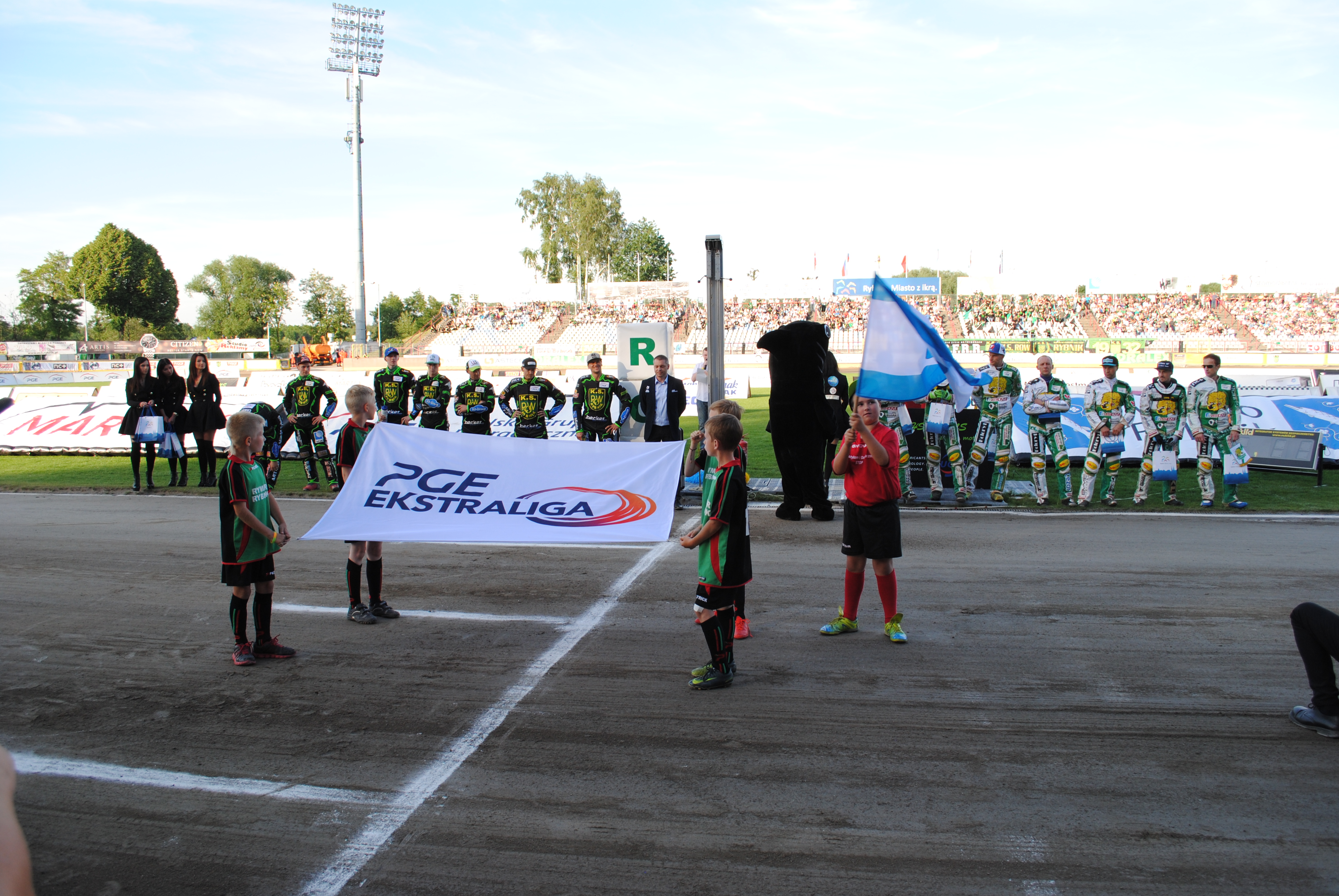 Chłopcy z Rymera z flagą głównego sponsora PGE Ekstraliga i Miasta Rybnik na stadionie ROWu