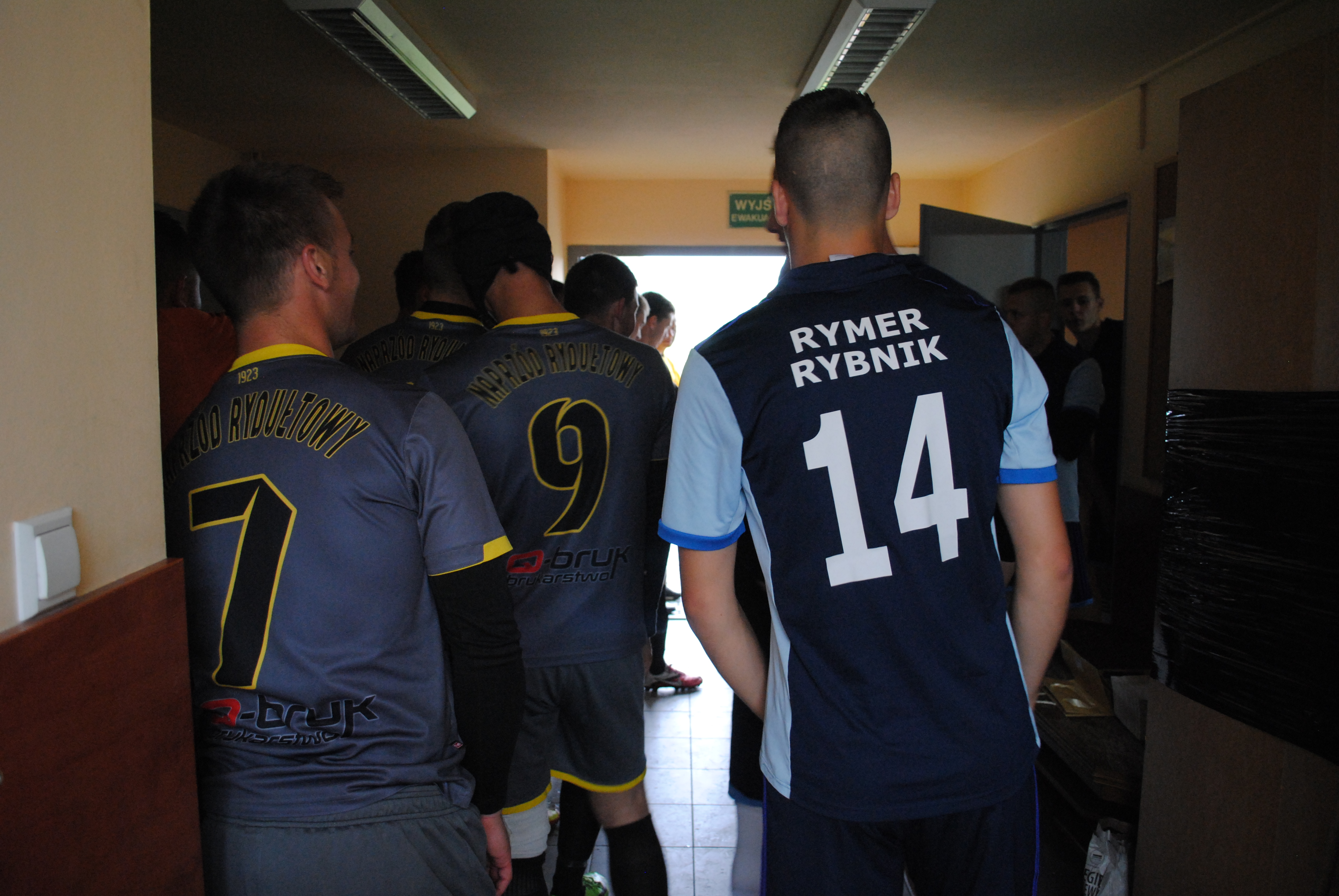 Zawodnicy Rymera i Naprzodu Rydułtowy stoją w tunelu przed wyjściem na murawę